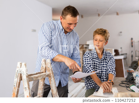 Father and his young son discussing work plan in construction site 110427252