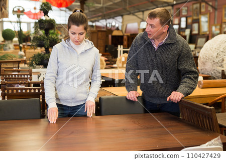 Couple selecting furniture in furnishing salon Couple selecting furniture in furnishing salon 110427429