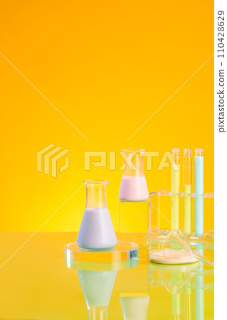 Minimal background with erlenmeyer flask and test tubes containing color liquid and displayed on glass podiums on yellow background. Laboratory concept, copy space 110428629