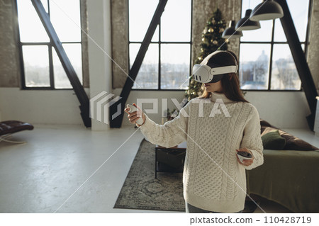 Describing her impressions, a beautiful girl in a VR headset shares her thoughts. Describing her impressions, a beautiful girl in a VR headset shares her thoughts. 110428719