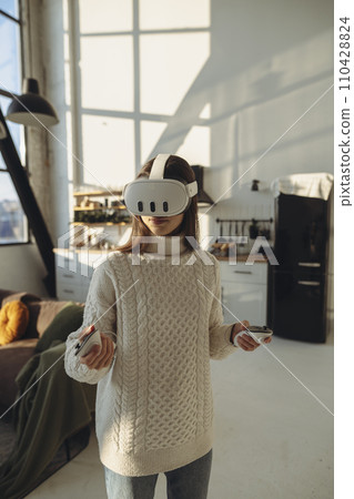The beautiful young woman in a VR headset is describing her experiences. The beautiful young woman in a VR headset is describing her experiences. 110428824