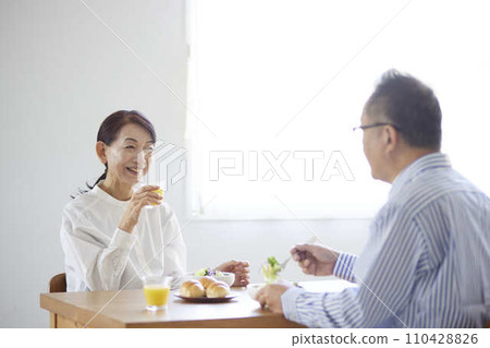 Japanese senior couple eating breakfast in the living room Japanese senior couple eating breakfast in the living room 110428826