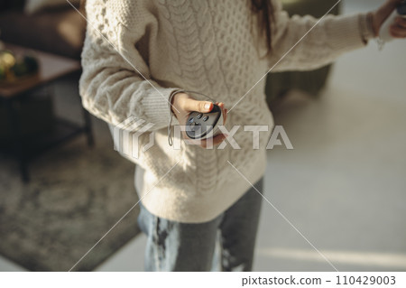 With sunlight streaming in, an active young woman explores virtual reality at home. With sunlight streaming in, an active young woman explores virtual reality at home. 110429003