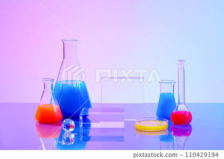 Red and blue liquids are stored in glassware with a transparent podium on a gradient background. Ideal space for display with simulation laboratory. Red and blue liquids are stored in glassware with a transparent podium on a gradient background. Ideal space for display with simulation laboratory. 110429194