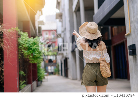 Happy youth asian woman with camera travels street city trip on leisure weekend. Young hipster female tourist sightseeing summer urban Bangkok destination. Asia summer tourism concept. 110430784