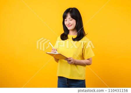 Experience the joy of education technology with portrait. A young Asian woman wearing a yellow t-shirt and denim jeans showcases a happy smile while using digital tablet. education technology concept. Experience the joy of education technology with portrait. A young Asian woman wearing a yellow t-shirt and denim jeans showcases a happy smile while using digital tablet. education technology concept. 110431156