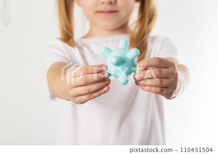 A blonde girl holds a model of a virus in her hands. Concept of infectious diseases in children, chickenpox and viral mumps, close-up A blonde girl holds a model of a virus in her hands. Concept of infectious diseases in children, chickenpox and viral mumps, close-up 110431504