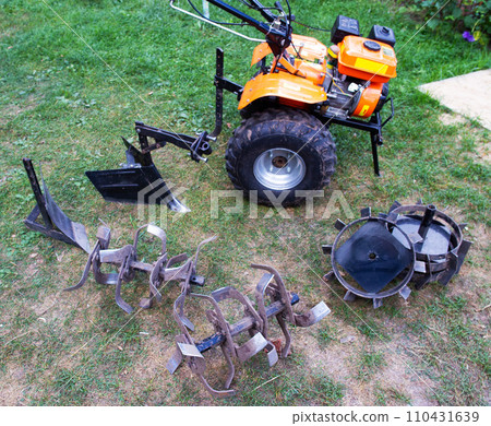 Agricultural walk-behind tractor with a set of attachments, hiller, milling cutters and lugs. Two-wheel tractor, industry Agricultural walk-behind tractor with a set of attachments, hiller, milling cutters and lugs. Two-wheel tractor, industry 110431639