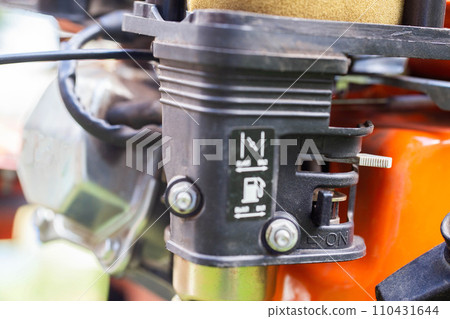 Carburetor with a cold start damper on a walk-behind tractor, close-up 110431644