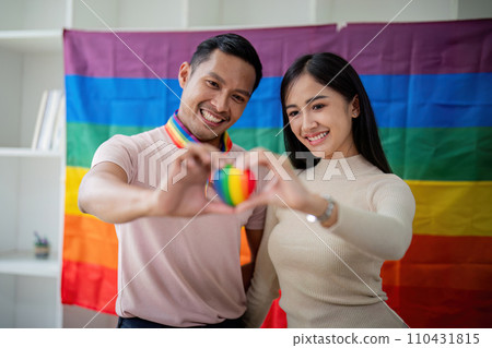 Young gay male and girl friend hands holding rainbow heart with smile face. LGBT, human rights and equality social Young gay male and girl friend hands holding rainbow heart with smile face. LGBT, human rights and equality social 110431815