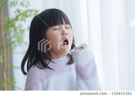 Yawning child in pajamas 110433162