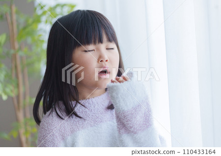 Yawning child in pajamas 110433164
