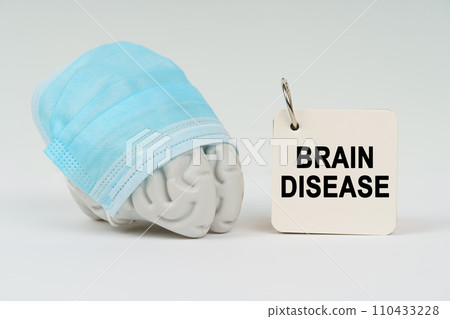 On a white surface next to the brain there is a notepad with the inscription - Brain Disease 110433228
