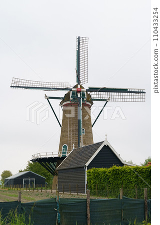 Windmill in a Dutch village. 110433254