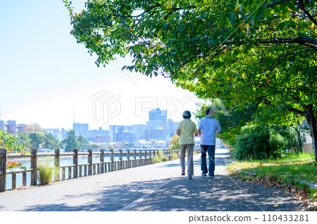 Active senior couple walking for health, diet, exercise, walk, backlight, morning color 110433281