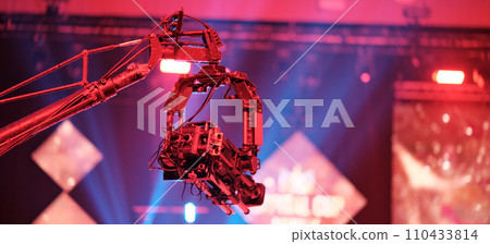 TV camera on a crane at a football match or concert. Close-up live video broadcast camera TV camera on a crane at a football match or concert. Close-up live video broadcast camera 110433814