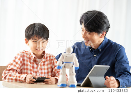 A boy who moves a robot and his father who watches over him 110433883