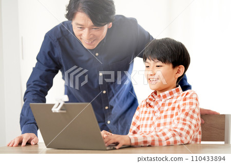 小學生和他的父親盯著筆記型電腦螢幕 小學生和他的父親盯著筆記型電腦螢幕 110433894