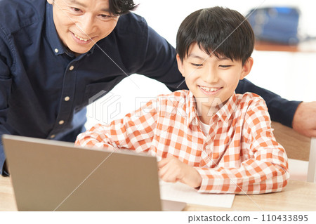 小學生和成年男子盯著筆記型電腦螢幕 110433895