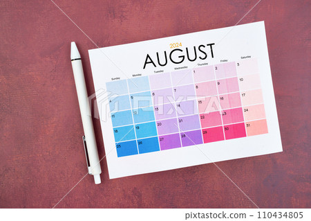 August 2024 calendar page and pen on red color retro. 110434805