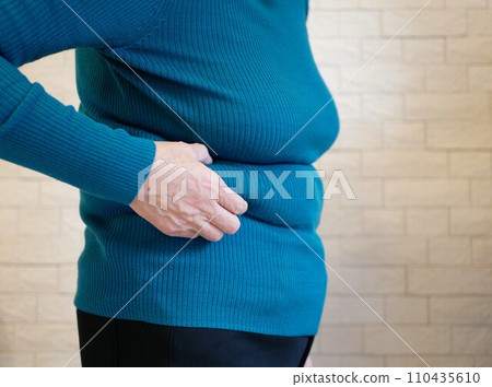 Sideways view of an elderly woman suffering from obesity 110435610