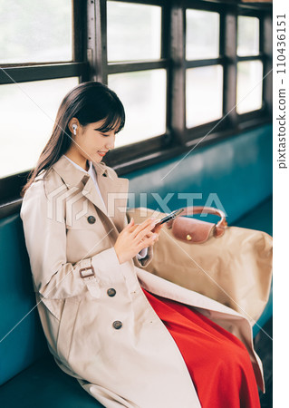 Woman listening to music by train 110436151
