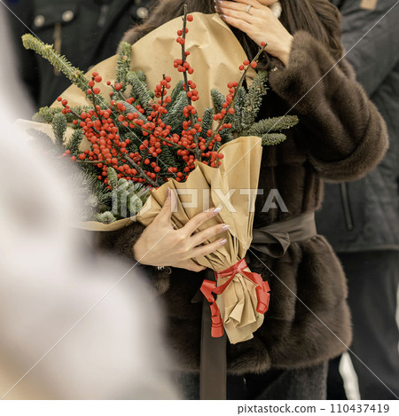Woman hands holding bouquet of red ilex verticillata, winterberry for Christmas decoration Woman hands holding bouquet of red ilex verticillata, winterberry for Christmas decoration 110437419