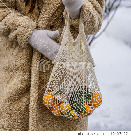Hands of girl with reusable cotton shopping mesh bag with citrus fruits. Concept of No plastic, Zero waste, plastic free Hands of girl with reusable cotton shopping mesh bag with citrus fruits. Concept of No plastic, Zero waste, plastic free 110437422