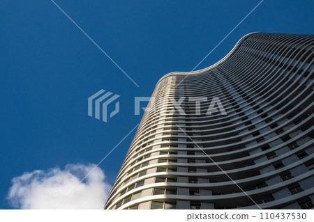 Curvilinear modern skyscrapers soar against a clear blue sky 110437530