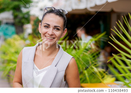 Happy businesswoman smiling while standing in suit on city street. 110438493