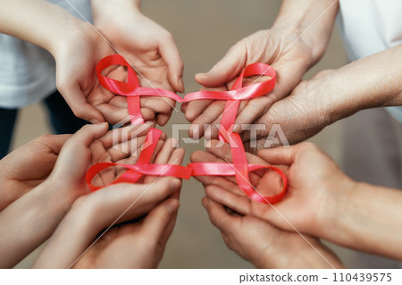 Hands of women with pink ribbon 110439575