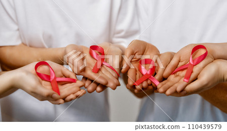 Hands of women with pink ribbon 110439579