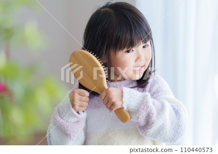 一個孩子早上用髮刷梳理頭髮 110440573