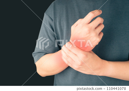 Man suffering from wrist hand pain over black background. Causes of hurt include carpal tunnel syndrome, fractures, arthritis or trigger finger. Health care concept. Copy space. 110441078