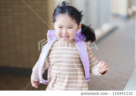 Elementary school children walking to and from school carrying school bags on their backs 110441132