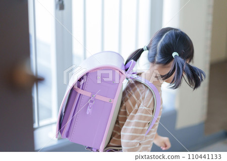 Elementary school children walking to and from school carrying school bags on their backs 110441133