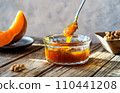 Autumn Harvest Pumpkin and walnuts Jam on wooden table, spoon with jam 110441208
