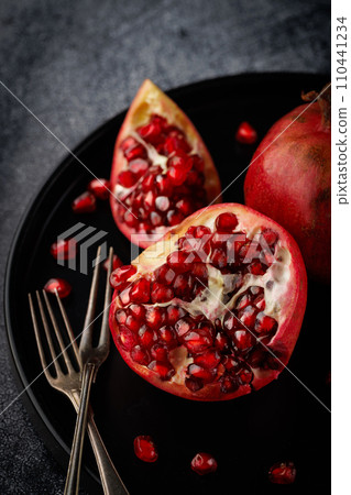 Pomegranate. Parts of a whole Pomegranate on a dark background. Pomegranate. Parts of a whole Pomegranate on a dark background. 110441234