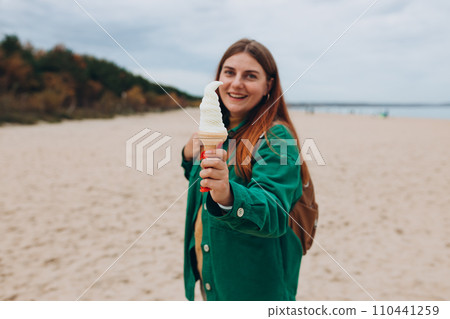 Happy 30s Woman eating traditional italian white ice cream gelato. Food concept. Funky girl having fun, lifestyle Happy 30s Woman eating traditional italian white ice cream gelato. Food concept. Funky girl having fun, lifestyle 110441259