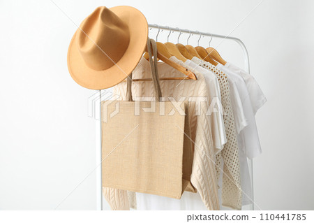 A bag hangs on a hanger with clothes 110441785