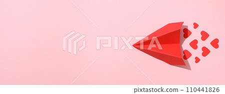 Red paper airplane with hearts on a pink background. Red paper airplane with hearts on a pink background. 110441826