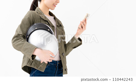 一個拿著頭盔、拿著智慧型手機的女人 110442243