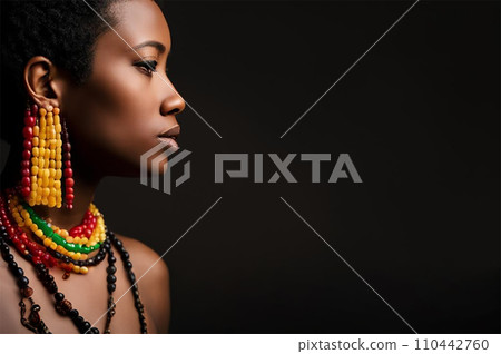 Side view of a sexy stylish black girl in traditional African jewelry on her naked body, with her eyes closed. An attractive young woman on a dark background. A place to copy 110442760