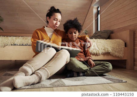 Young mother reading book to cute son 110443150