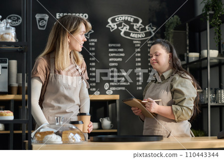 Girl with notepad looking at colleague 110443344