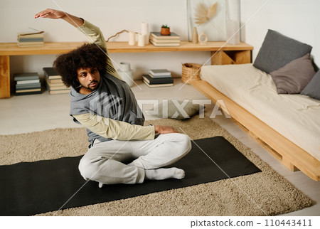 Man in activewear doing side bends 110443411