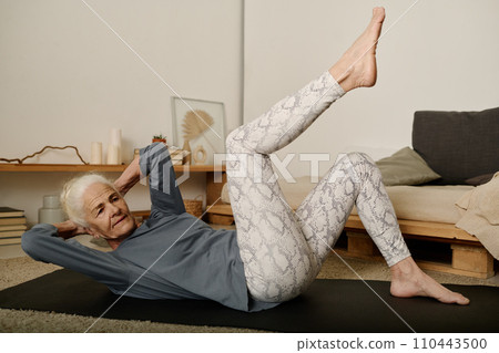 Woman doing physical exercise on mat Woman doing physical exercise on mat 110443500