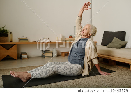 Woman doing side bends with raised arm Woman doing side bends with raised arm 110443579