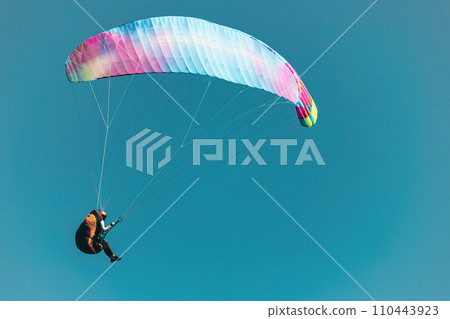 Paraglider in the sky. The sportsman flying on a paraglider. 110443923