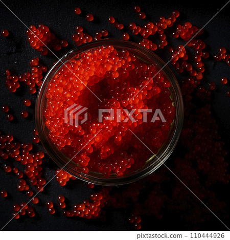 Red caviar, a jar with fresh appetizing, tasty caviar on a black background, top view, flatley, for advertising and design of fish stores 110444926